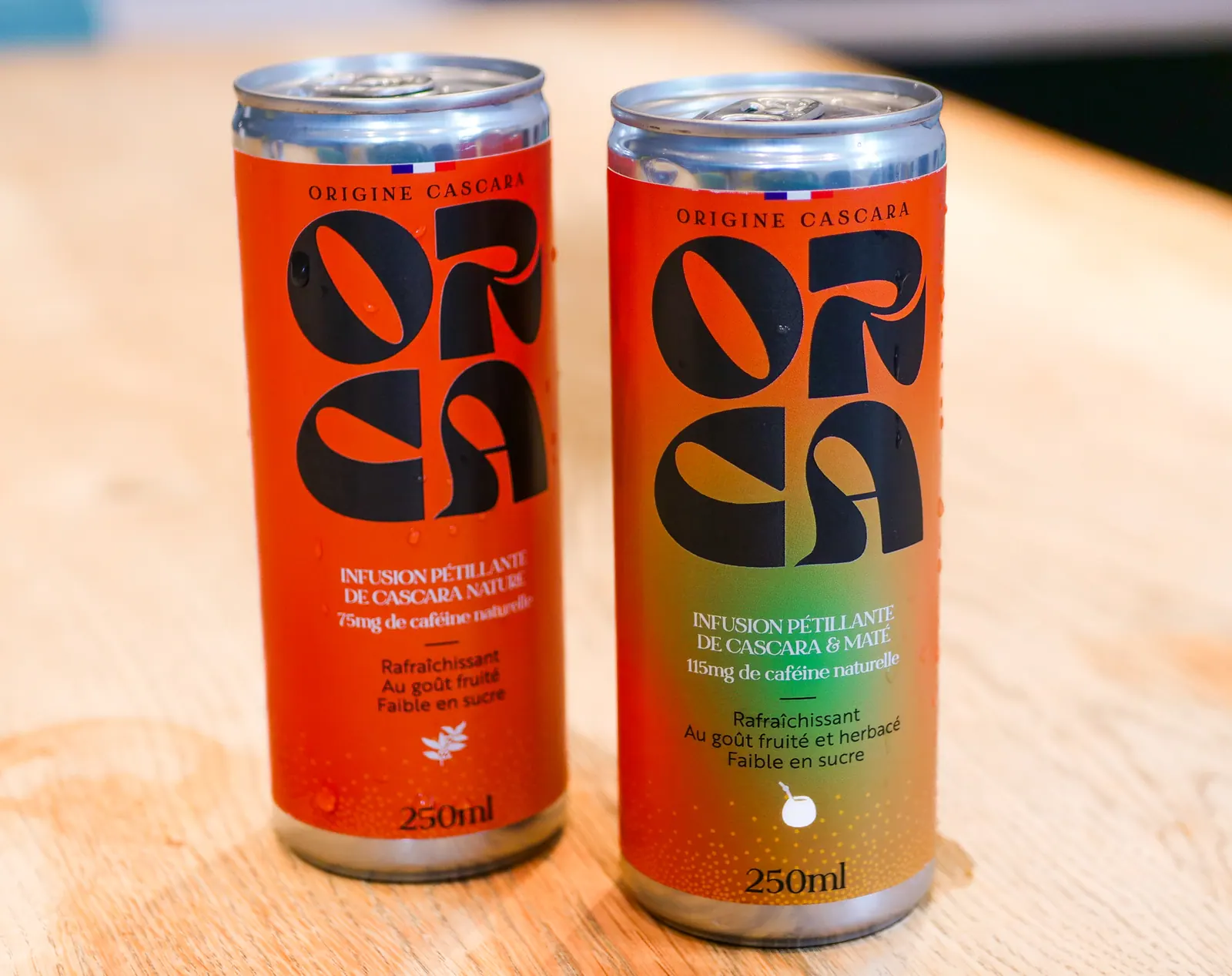 Les deux canettes ORCA fraîches, couvertes de condensation, sur du bois